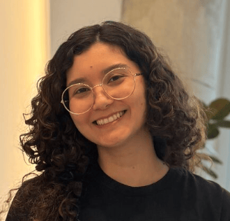a person with curly hair wearing glasses