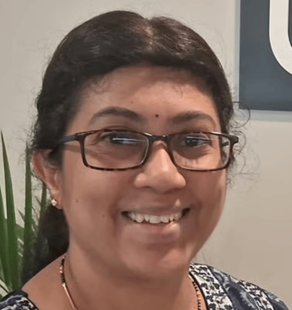 a person wearing glasses and smiling