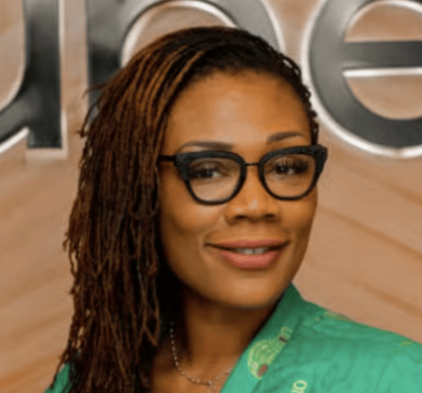 a person wearing glasses and a green jacket